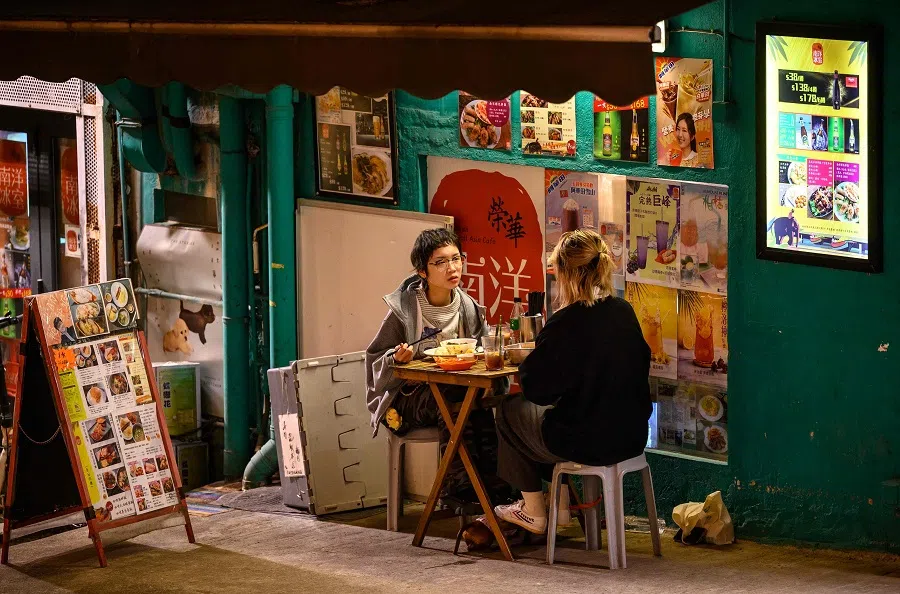 People have dinner on the street outside a restaurant in Hong Kong on 9 January 2025. (Mladen Antonov/AFP)