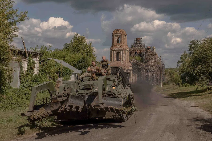 TOPSHOT - Ukrainian servicemen operate an armoured military vehicle on a road near the border with Russia, in the Sumy region of Ukraine, on August 14, 2024. The Ukrainian army entered Russia's Kursk region on August 6, capturing dozens of settlements in the biggest offensive by a foreign army on Russian soil since World War II. (Photo by Roman PILIPEY / AFP)