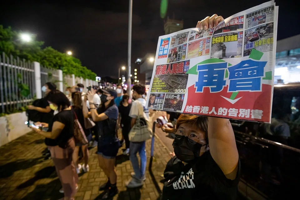 A supporter holds the final edition of the newspaper outside the headquarters of the Apple Daily newspaper and its publisher Next Digital Ltd. in Hong Kong, China, on 24 June 2021. (Paul Yeung/Bloomberg)