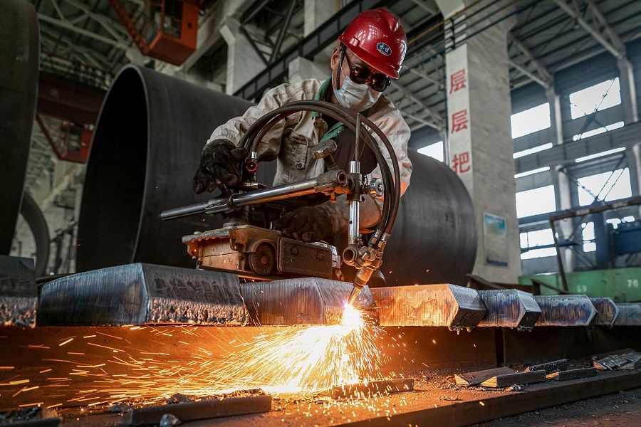 A worker produces a manufacturing machine at a factory in Nantong, Jiangsu province, China on 26 May 2021. (STR/AFP)