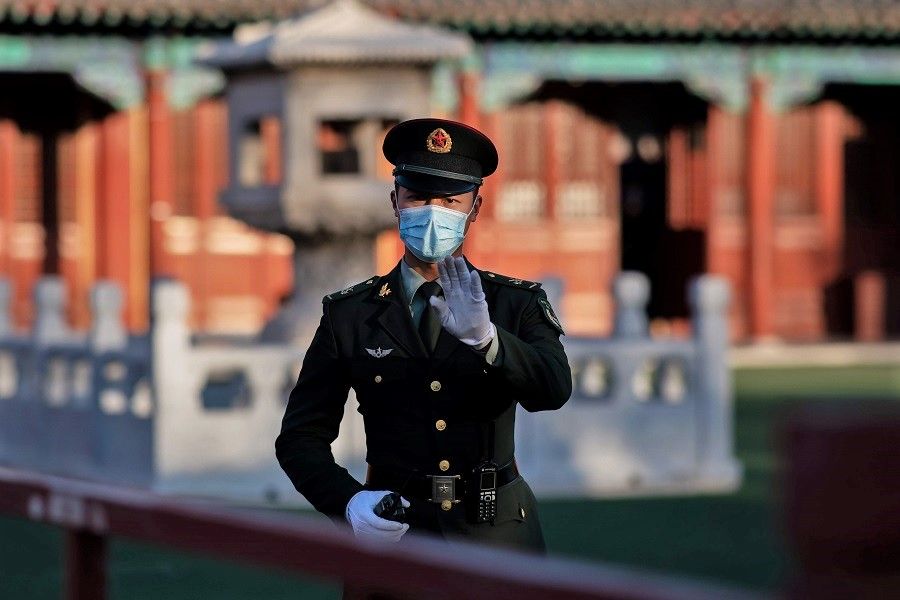 A soldier wearing a face mask gestures outside the Forbidden City in Beijing on 22 October 2020. (Nicolas Asfouri/AFP)