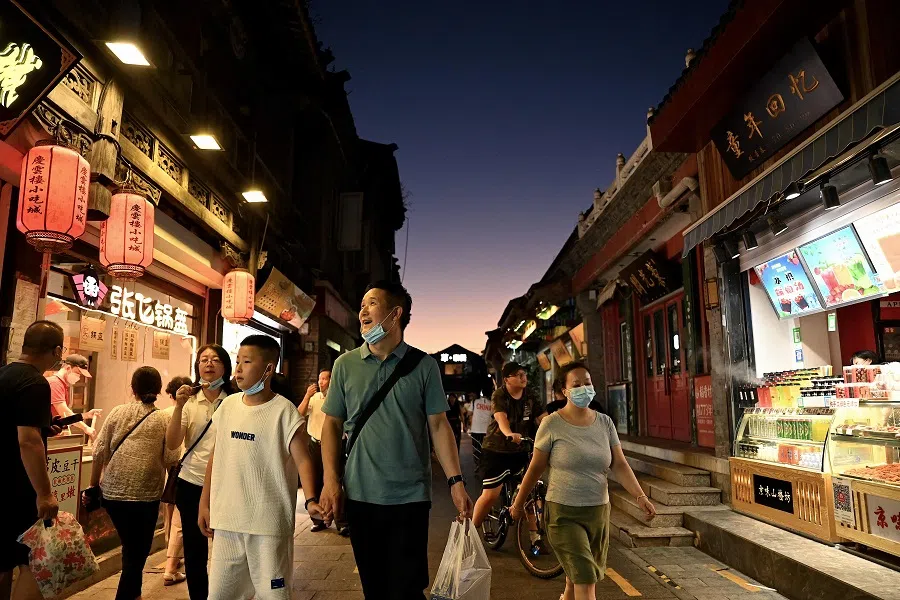 People walk along a hutong near Houhai in Beijing, China, on 15 August 2022. (Noel Celis/AFP)