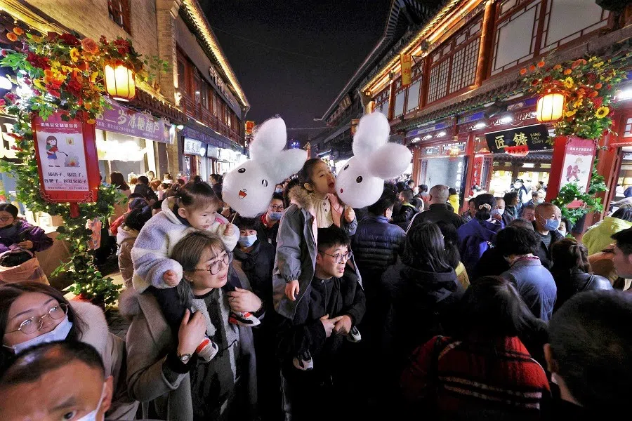 People walk on a commercial street in Taiyuan, Shanxi province, China on 26 February 2021. (STR/AFP)