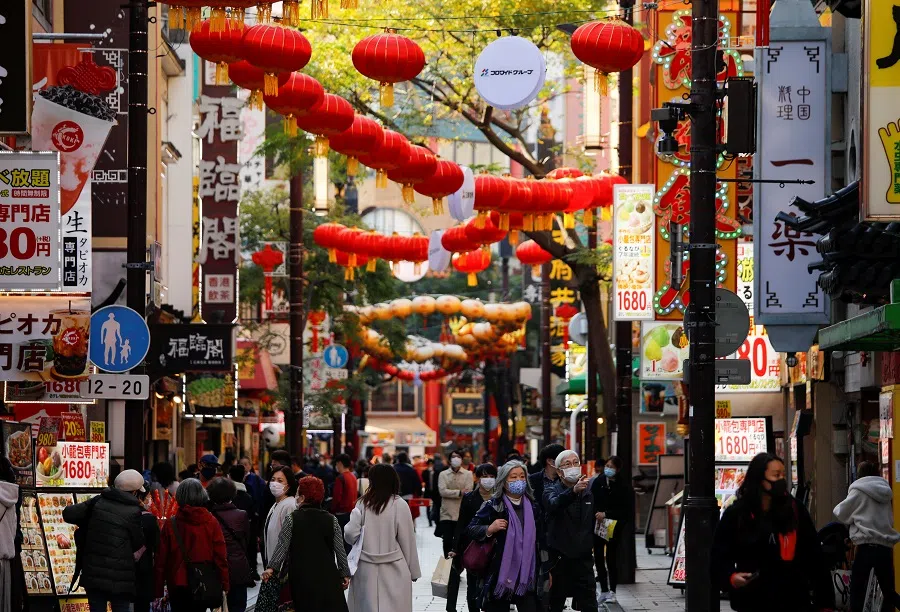 Passersby wearing protective face masks walk on the street at Yokohama's Chinatown, in Yokohama, Tokyo, Japan, 1 December 2020. (Issei Kato/Reuters)