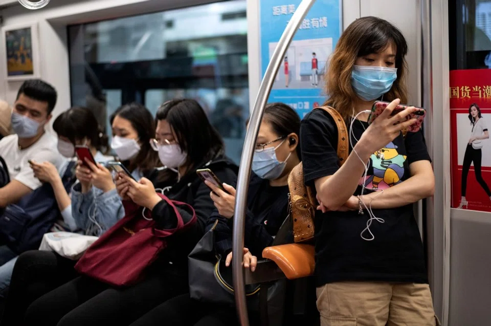 Passengers use their mobile phones on the subway in Beijing, 12 May 2020. (Noel Celis/AFP)