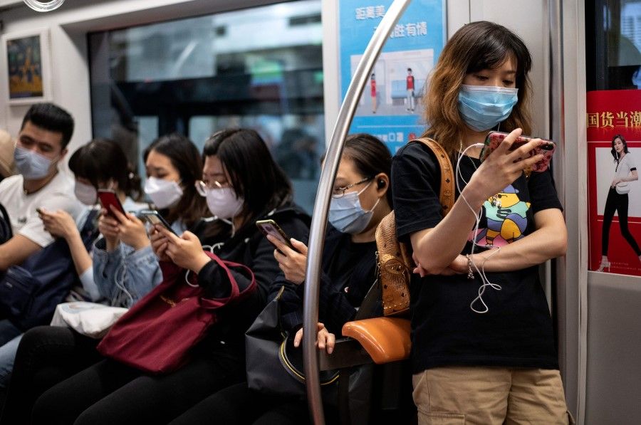 Passengers use their mobile phones on the subway in Beijing, 12 May 2020. (Noel Celis/AFP)
