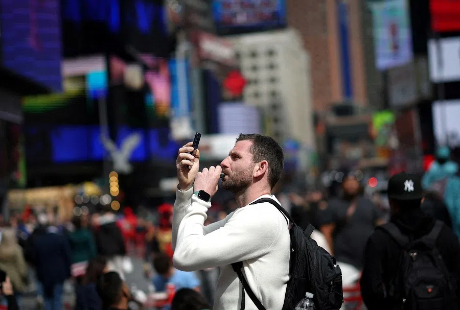 A man makes a video with a mobile phone he said was for posting on TikTok as he stands in Times Square in New York City, New York, US, on 13 March 2024. (Mike Segar/Reuters)