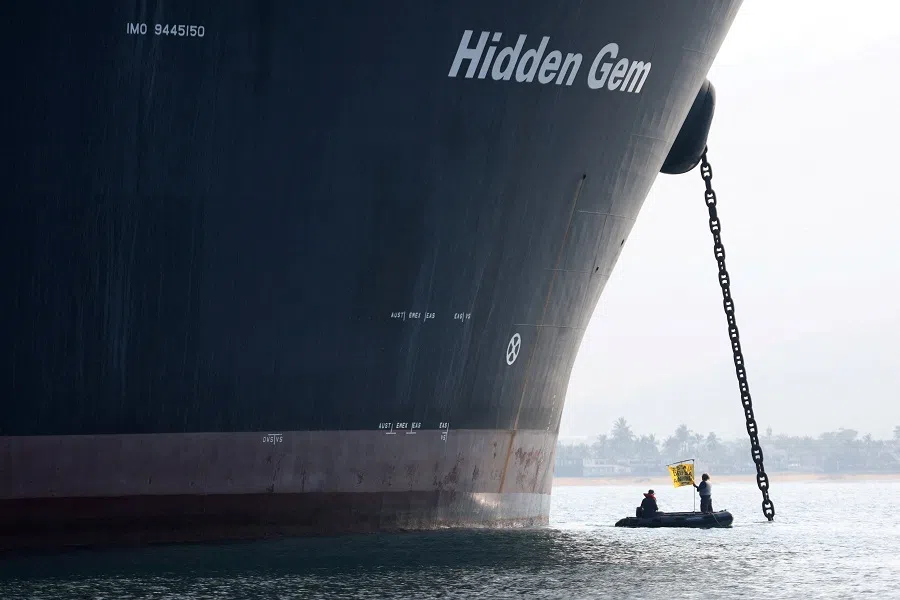 A Greenpeace activist holds a banner during a protest near the deep-sea mining vessel Hidden Gem, commissioned by Canadian miner The Metals Company, in the Mexican Pacific port of Manzanillo, in Manzanillo, Mexico, on 27 September 2023. (Gustavo Graf/Greenpeace Mexico/Handout via Reuters)