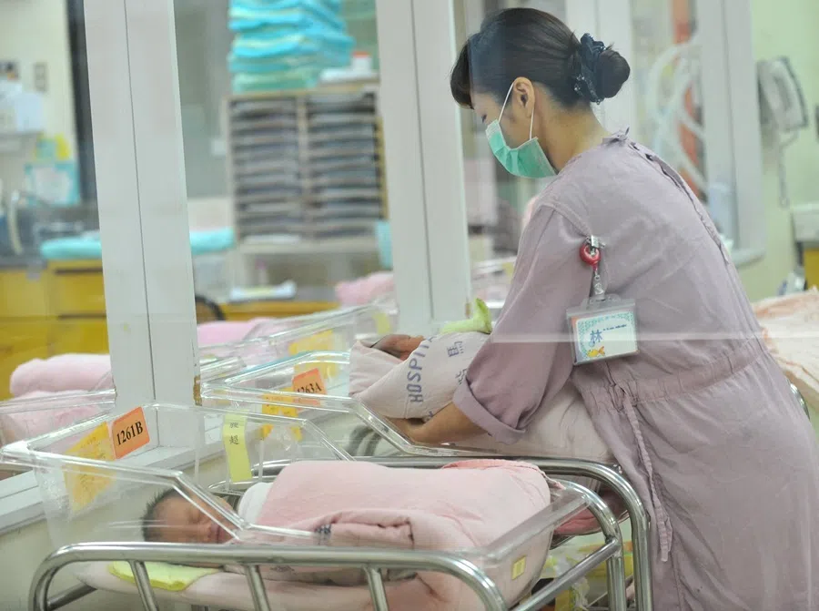 A nurse inspects a newborn baby at a nursery in a hospital in Taipei on 8 July 2011.