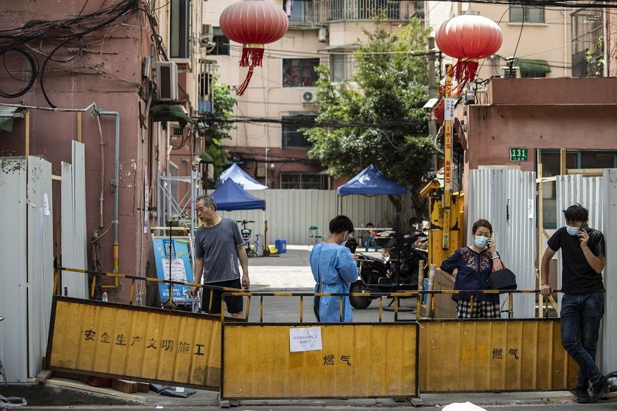 Residents behind barriers surrounding a residential neighbourhood placed under lockdown due to Covid-19 in Shanghai, China, on 6 July 2022. (Qilai Shen/Bloomberg)