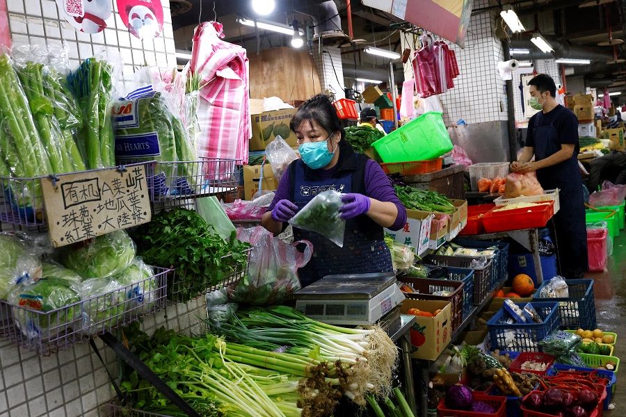 People buy and sell vegetables in Taipei, Taiwan, 17 January 2023. (Ann Wang/Reuters)