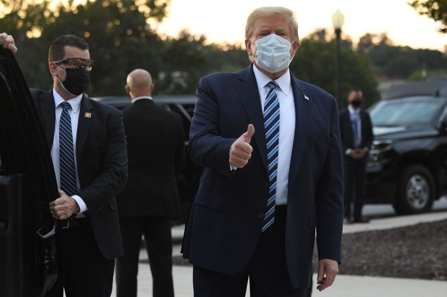 US President Donald Trump walking out of Walter Reed Medical Center in Bethesda, Maryland before heading to Marine One on 5 October 2020, to return to the White House after being discharged. (Saul Loeb/AFP)