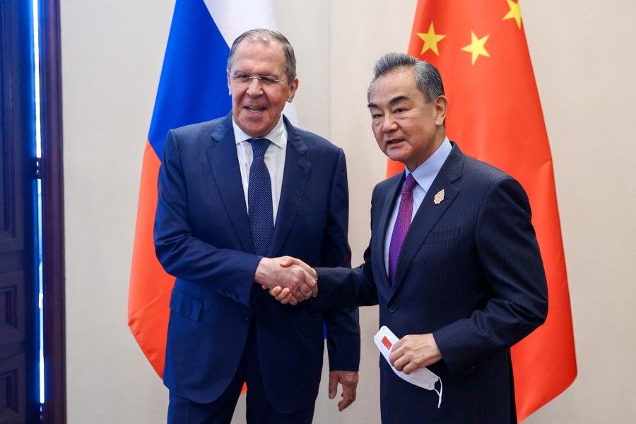 Russian Foreign Minister Sergei Lavrov and Chinese Foreign Minister Wang Yi shake hands as they meet in Denpasar, Indonesia, 7 July 2022. (Russian Foreign Ministry/Handout via Reuters)