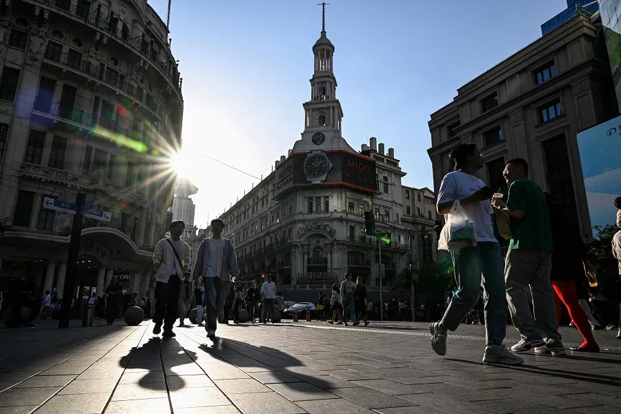 People walk on a pedestrian street in the Huangpu district, in Shanghai, China, on 30 March 2024. (Hector Retamal/AFP)