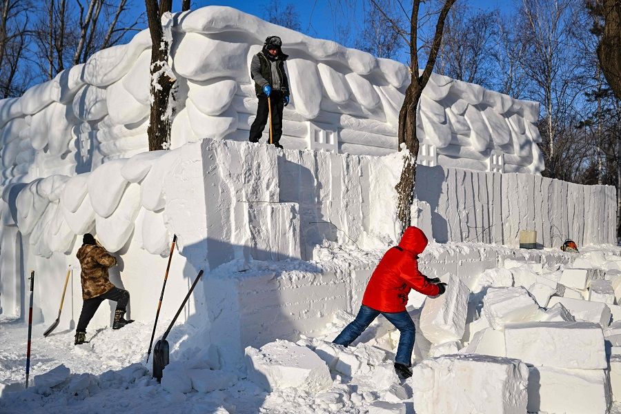 Men build a snow house at the Harbin Sun Island International Snow Sculpture Art Expo in Harbin, Heilongjiang province, China, on 4 January 2023. (Hector Retamal/AFP)