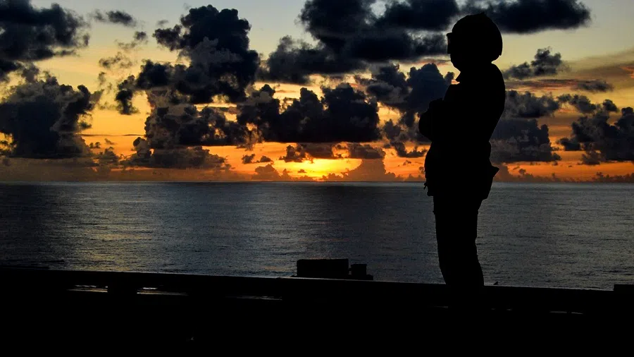 A US Navy sailor signals to an MH-60R Sea Hawk helicopter during flight operations aboard the aircraft carrier USS Ronald Reagan in the South China Sea, 17 July 2020. (US Navy/Mass Communication Specialist 2nd Class Codie L. Soule/Handout via Reuters)