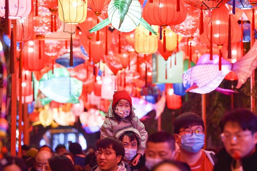 This photo taken on 31 January 2023 shows people walking under lanterns at a street in Nanjing, Jiangsu province, China. (AFP)