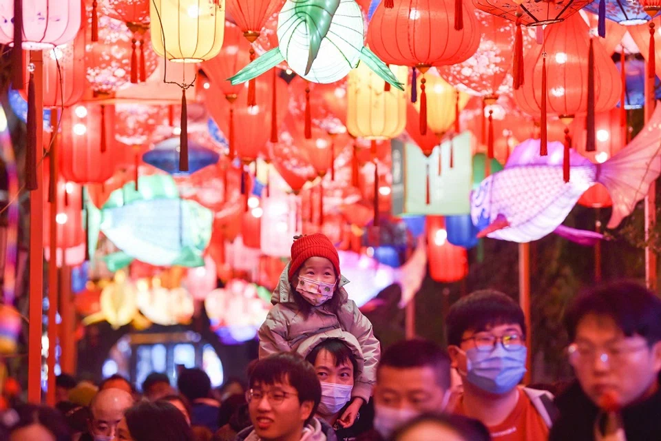 This photo taken on 31 January 2023 shows people walking under lanterns at a street in Nanjing, Jiangsu province, China. (AFP)