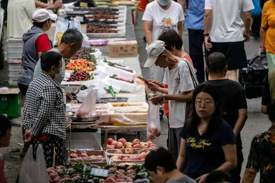 Shoppers at fruit stalls at a market in Dalian, China, on 25 June 2026.