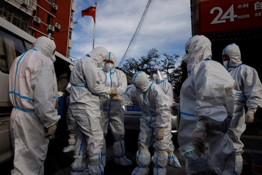 Pandemic prevention workers in protective suits prepare to enter an apartment compound that was placed under lockdown as outbreaks of the coronavirus disease (Covid-19) continue in Beijing, China, 12 November 2022. (Thomas Peter/Reuters)