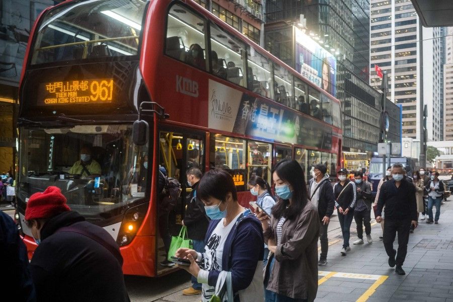 Commuters stand in a bus queue in Hong Kong on 23 March 2021. (Anthony Wallace/AFP)