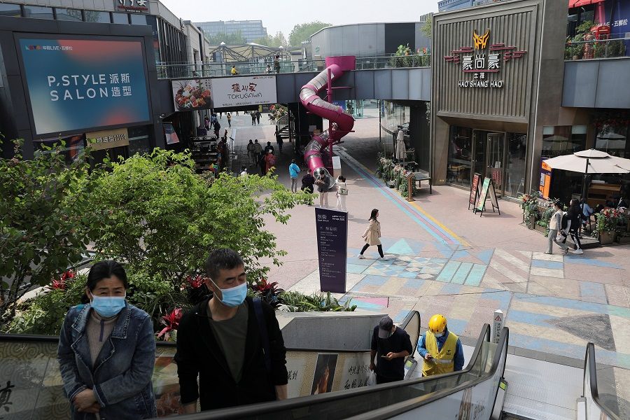 People visit a shopping complex in Beijing, China on 15 April 2021. (Tingshu Wang/Reuters)