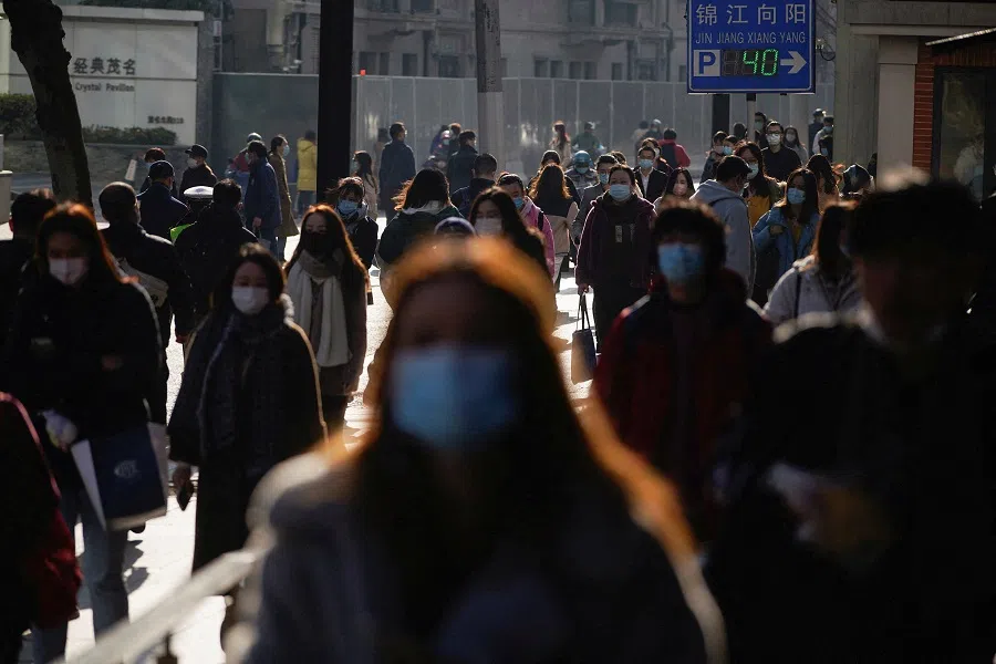 People wearing protective masks walk on a street in Shanghai, China, 20 December 2021. (Aly Song/File Photo/Reuters)