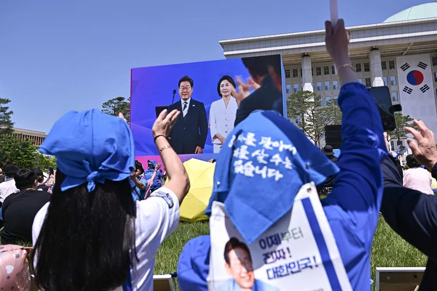 People cheer as they watch the inauguration ceremony of South Korea’s President Lee Jae-myung outside the National Assembly in Seoul on 4 June 2025. (Pedro Pardo/AFP)