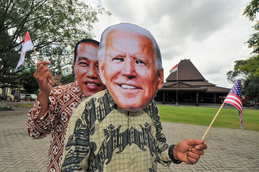 People wearing masks depicting the faces of Indonesian President Joko Widodo (left) and US President Joe Biden (right) pose in Surakarta, Central Java, Indonesia, on 20 January 2020, ahead of Biden's presidential inauguration later in the day. (Anwar Mustafa/AFP)