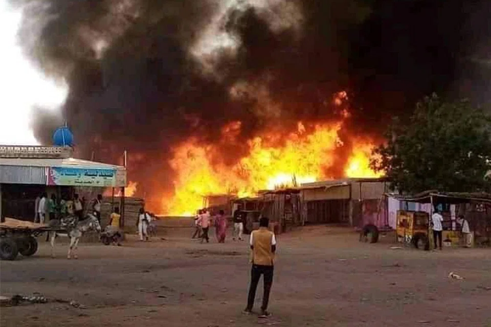 A man stands by as a fire rages in a livestock market area in al-Fasher, the capital of Sudan's North Darfur state on 1 September 2023, in the aftermath of bombardment by the paramilitary Rapid Support Forces. (AFP)