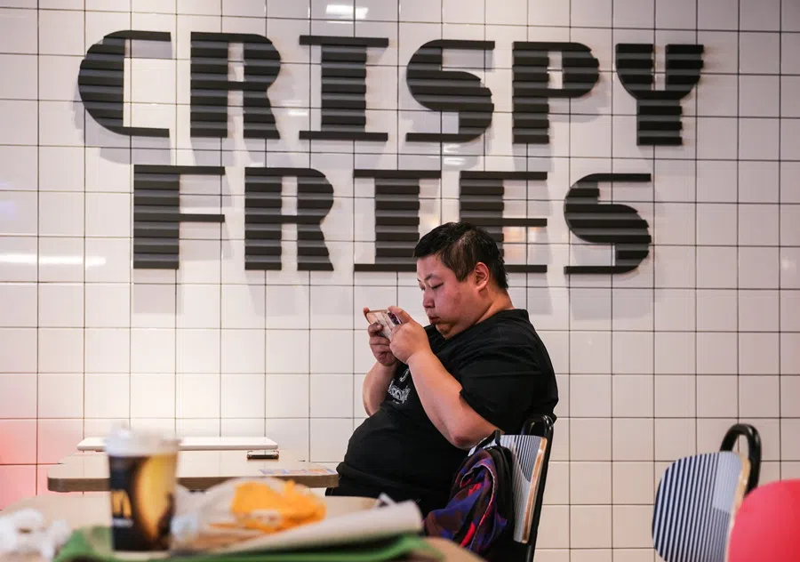 A man uses his smartphone at a McDonald's restaurant in Beijing, China, on 23 September 2025. (Maxim Shemetov/Reuters)