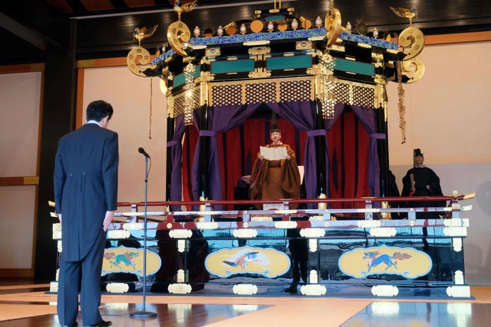 Japanese Prime Minister Shinzo Abe (L) and Emperor Naruhito (C) during the Emperor's enthronement ceremony at the Imperial Palace in Tokyo. Note Mr Abe's tailcoat and the Emperor's robe. (AFP)