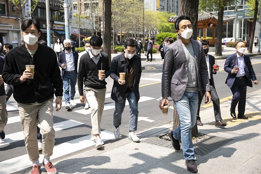 People cross a road during lunch hour in the Gwanghwamun area of Seoul, South Korea, on 18 April 2022. (Woohae Cho/Bloomberg)