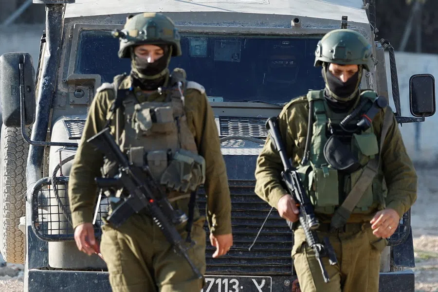 Israeli soldiers walk on the day they prevent Palestinians, who came to visit the graves of their relatives, from reaching the cemetery, in Jenin camp, in the Israeli-occupied West Bank, on 6 June 2025.  (Raneen Sawafta/Reuters)