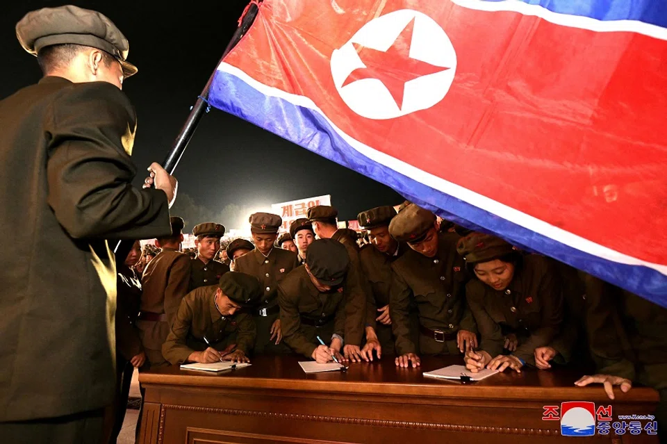 Young people, including students and youth league officials, sign petitions to join or return to the army, according to North Korean state media, at an undisclosed location in North Korea, in this undated photo released by North Korea’s official Korean Central News Agency on 16 October 2024. (KCNA via Reuters)