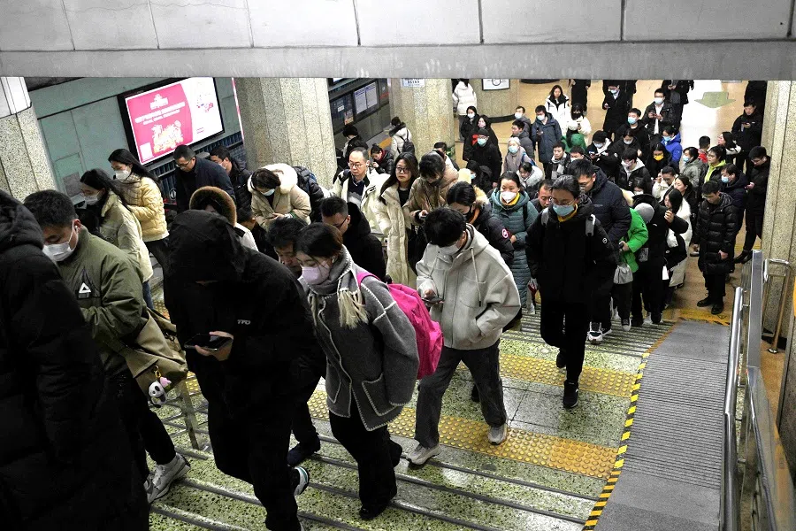 People are seen at a subway station in Beijing on 17 January 2024. (Pedro Pardo/AFP)