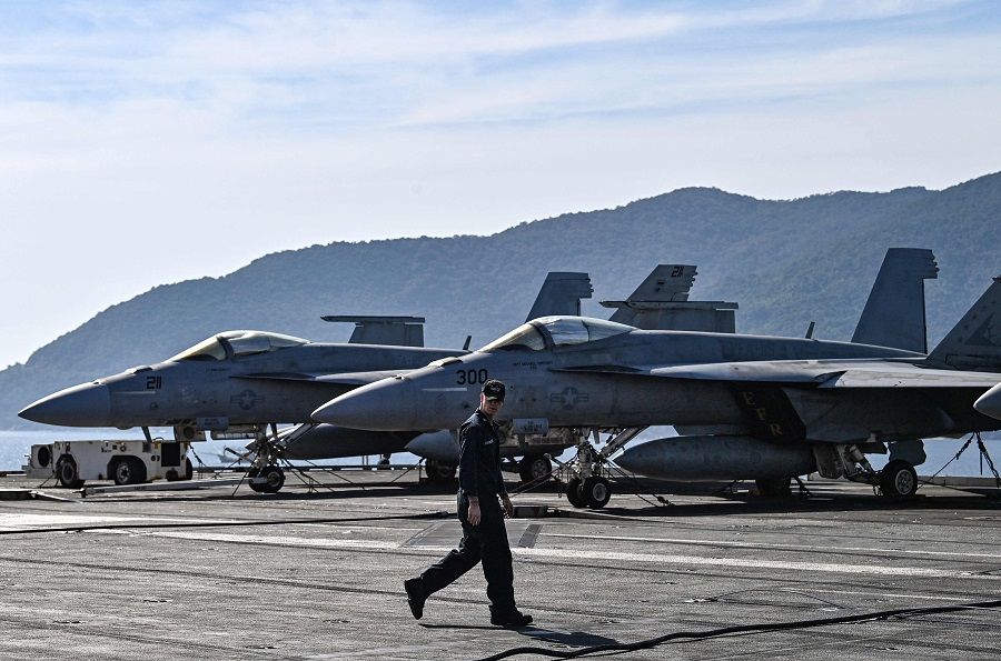 A sailor walks on the deck of the USS Ronald Reagan, a US Navy Nimitz-class nuclear-powered aircraft carrier, during a port visit in Danang, Vietnam, on 26 June 2023. (Nhac Nguyen/AFP)