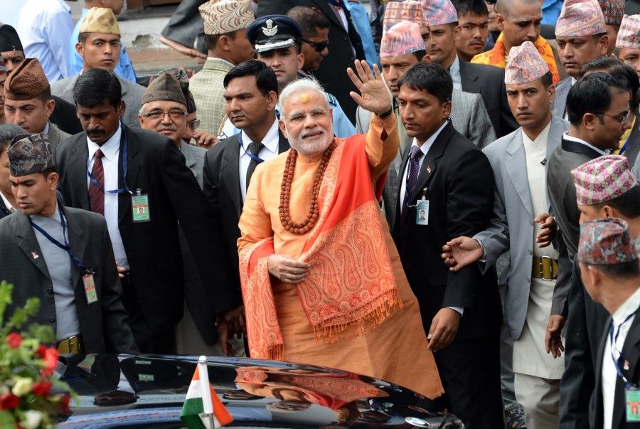 Indian Prime Minister Narendra Modi (centre) waves as he leaves following his visit to the Pashupatinath Temple in Kathmandu on 4 August 2014. Indian Prime Minister Narendra Modi arrived in Nepal to try to speed up progress on power agreements while also aiming to counter rival giant China's influence in the region. Modi flew into Kathmandu for talks on strengthening trade ties including harnessing Nepal's vast hydropower resources in the first visit by an Indian prime minister to the Himalayan nation in 17 years. (Prakash Mathema/AFP)
