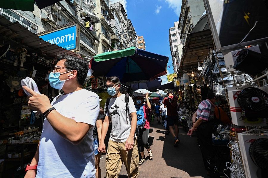 People walk through a market street in Hong Kong on 22 May 2021. (Peter Parks/AFP)