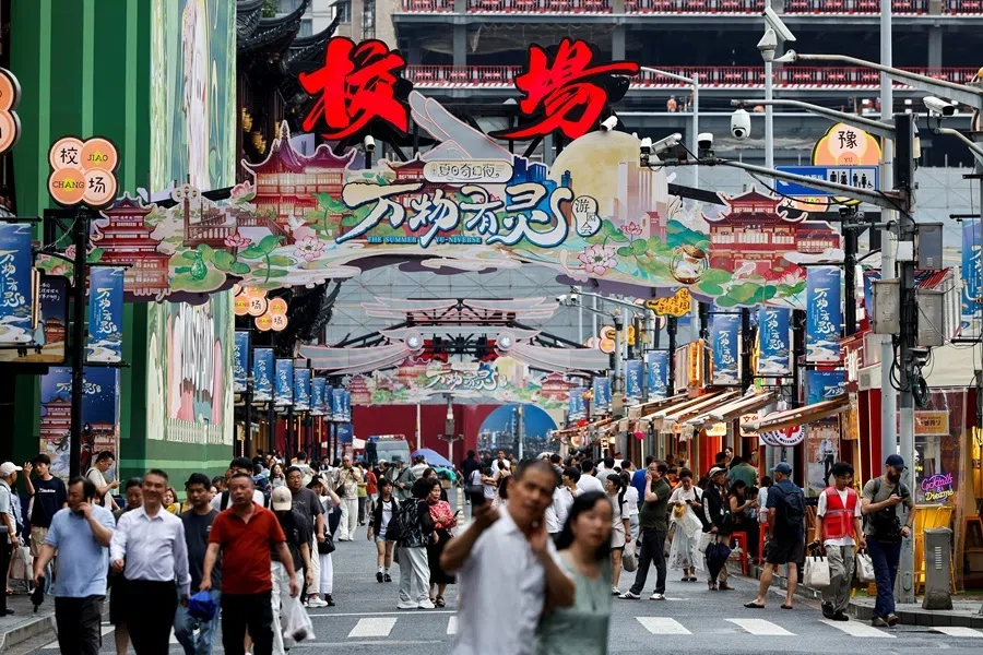 People walk along a shopping street in Shanghai, China, on 1 July 2026.