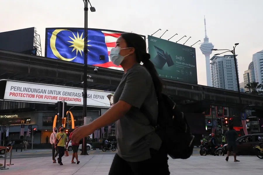People cross a street outside a shopping mall in Kuala Lumpur, Malaysia, 6 September 2021. (Lim Huey Teng/Reuters)