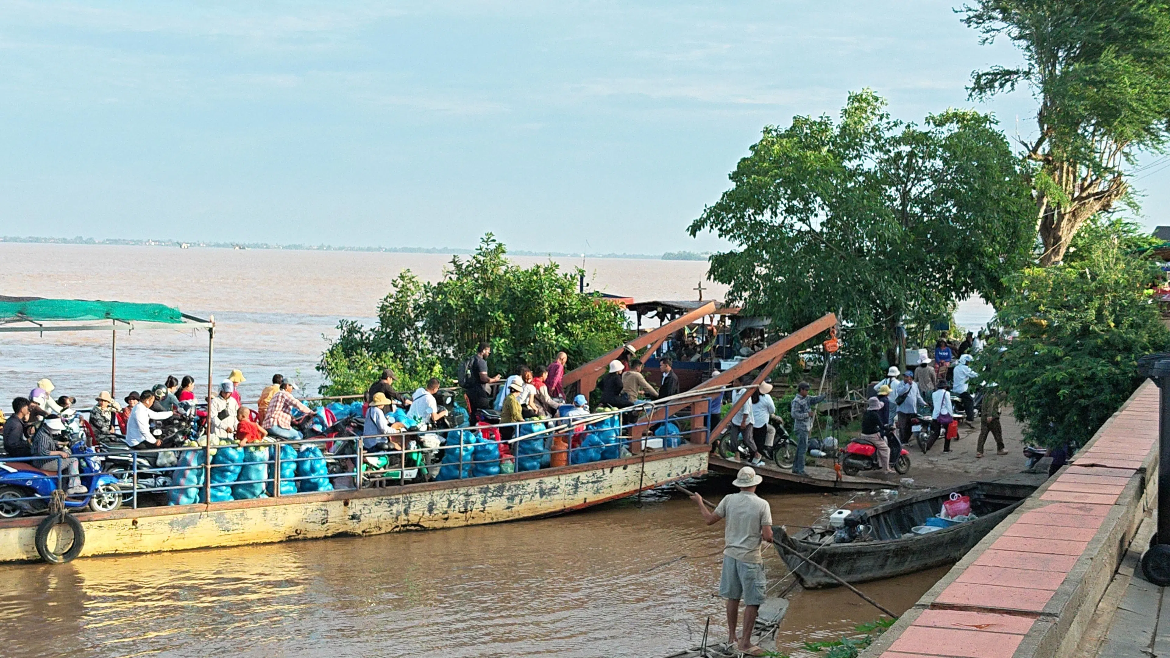 Arriving on the mainland from Koh Trong Island, Kratie province, aboard a ferry carrying passengers, motorbikes and agricultural produce.