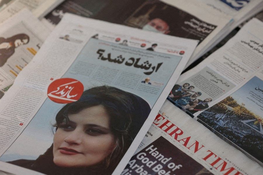 A newspaper with a cover picture of Mahsa Amini, a woman who died after being arrested by Iranian morality police is seen in Tehran, Iran, 18 September 2022. (Majid Asgaripour/West Asia News Agency via Reuters)