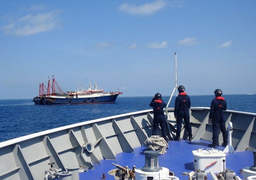 A handout picture made available by the Philippine Coast Guard (PCG) shows Filipino coastguard personnel aboard the BRP Cabra patrol ship monitoring Chinese vessels anchored at Sabina Shoal, in the disputed South China Sea on 27 April 2021 (issued on 05 May 2021). (Philippine Coast Guard/Handout)