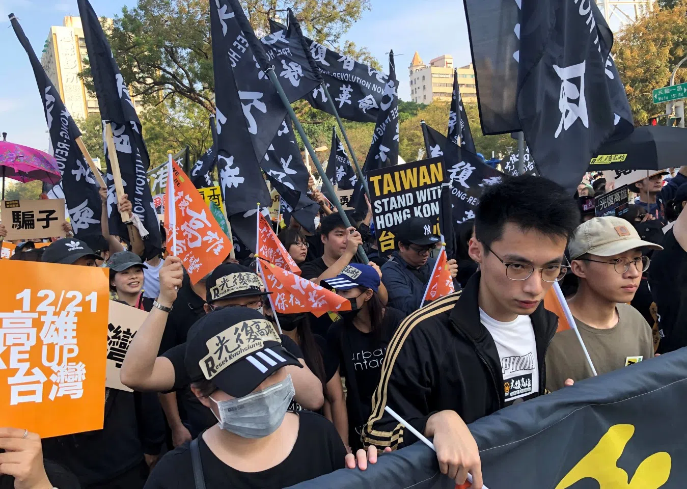 Protesters hold signs and flags in support of Hong Kong's pro-democracy protests, during a rally against main opposition Kuomintang party's presidential candidate Han Kuo-yu, in Kaohsiung, Taiwan on 21 December 2019. (Yimou Lee/Reuters)
