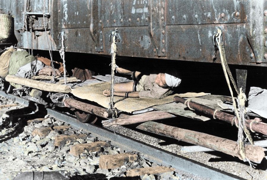 In 1938, refugees set up wooden beds under a train that has pulled into Sichuan. Chinese civilians fled to Chongqing by any means they could find over land or water.