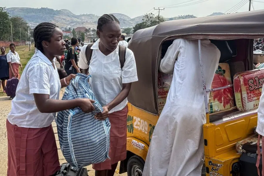Students load bags into a tuk-tuk outside the Federal Government Girls College in Bwari, on the outskirts of Abuja, on 22 November 2025. (John Okunyomih/AFP)