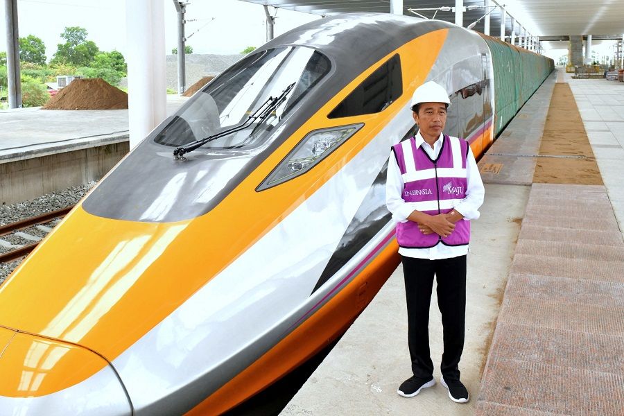 This handout picture taken and released on 13 October 2022 by Indonesia's presidential palace shows Indonesian President Joko Widodo standing next to a high-speed train at Tegalluar Station, in Bandung, Indonesia, which is planned to be tested with his Chinese counterpart, Xi Jinping, in November. (Handout/Presidential Palace/AFP)