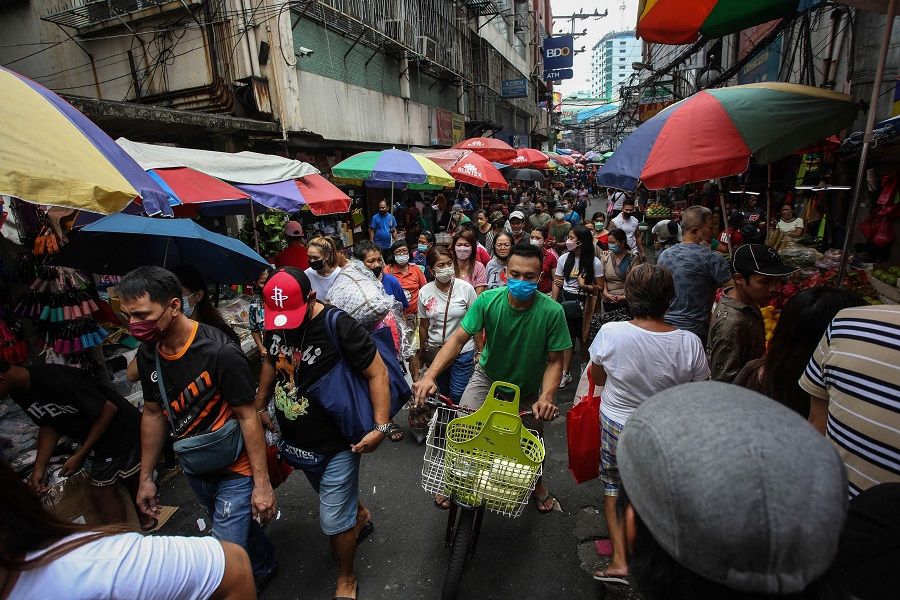 People walk along Divisoria, a local shopping district in Manila, Philippines, on 17 May 2022. (Jam Sta Rosa/AFP)