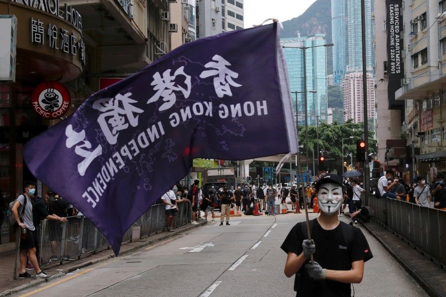 A masked anti-government protester holds a flag supporting Hong Kong independence during a march against Beijing's plans to impose national security legislation in Hong Kong, 24 May 2020. (Tyrone Siu/REUTERS)